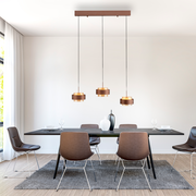 Moderne LED-Hängeleuchte mit drei Pendeln über einem Esstisch, seitliche Perspektive