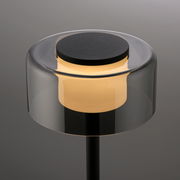 Moderne Tischleuchte RIKA mit zylindrischem, transparentem Schirm und warmem Licht, seitliche Perspektive