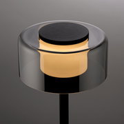 Moderne Tischleuchte RIKA mit zylindrischem, transparentem Schirm und warmem Licht, seitliche Perspektive