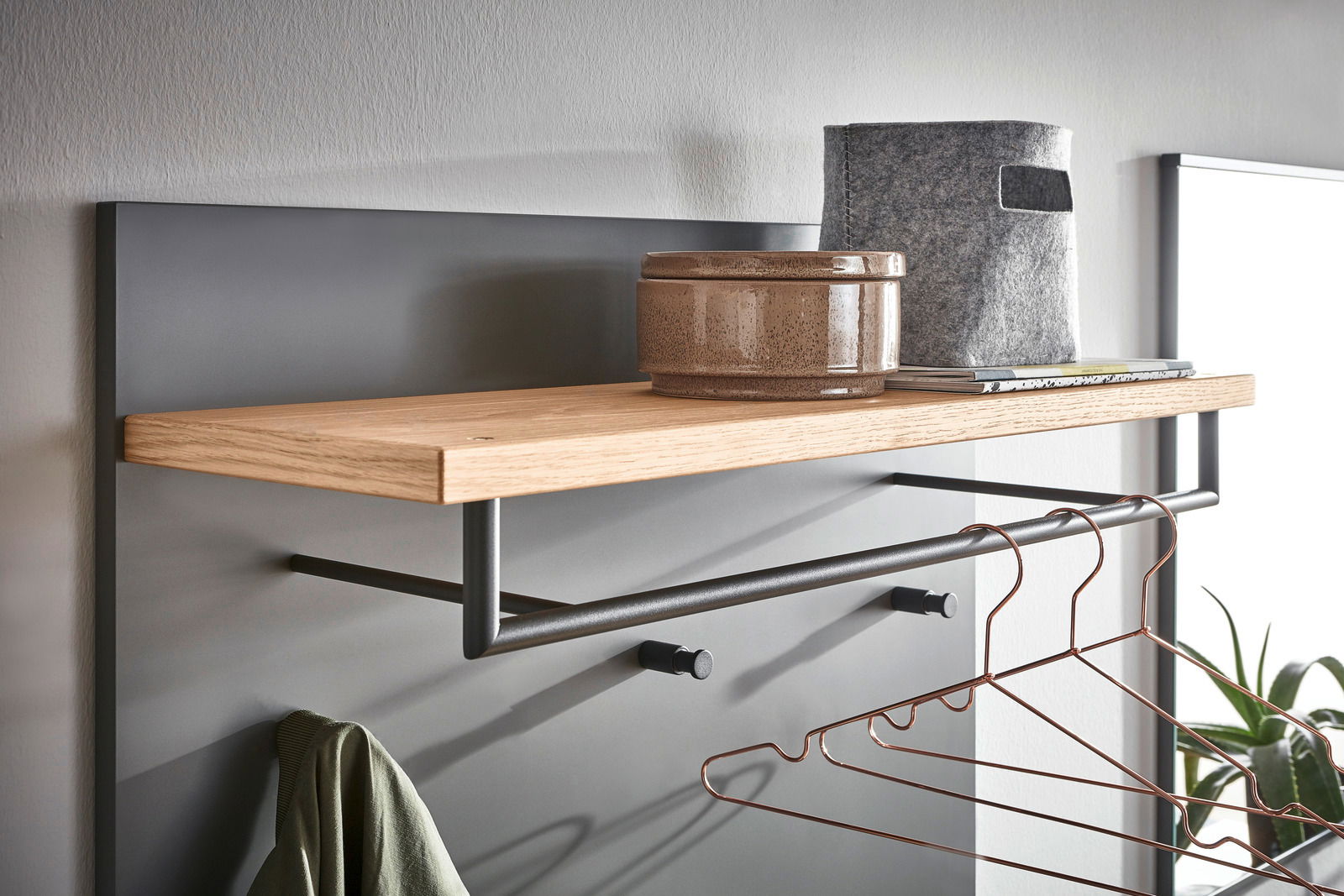 Nahaufnahme eines modernen Garderoben-Sets mit Holzablage, Kleiderstange und Haken, seitliche Perspektive.