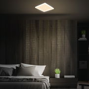 Quadratische LED-Deckenleuchte in einem modernen Schlafzimmer, von unten betrachtet.