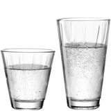 Zwei transparente Trinkgläser, eines kleiner und breiter, das andere größer und schmaler, gefüllt mit sprudelndem Wasser, aus der Seitenperspektive fotografiert.