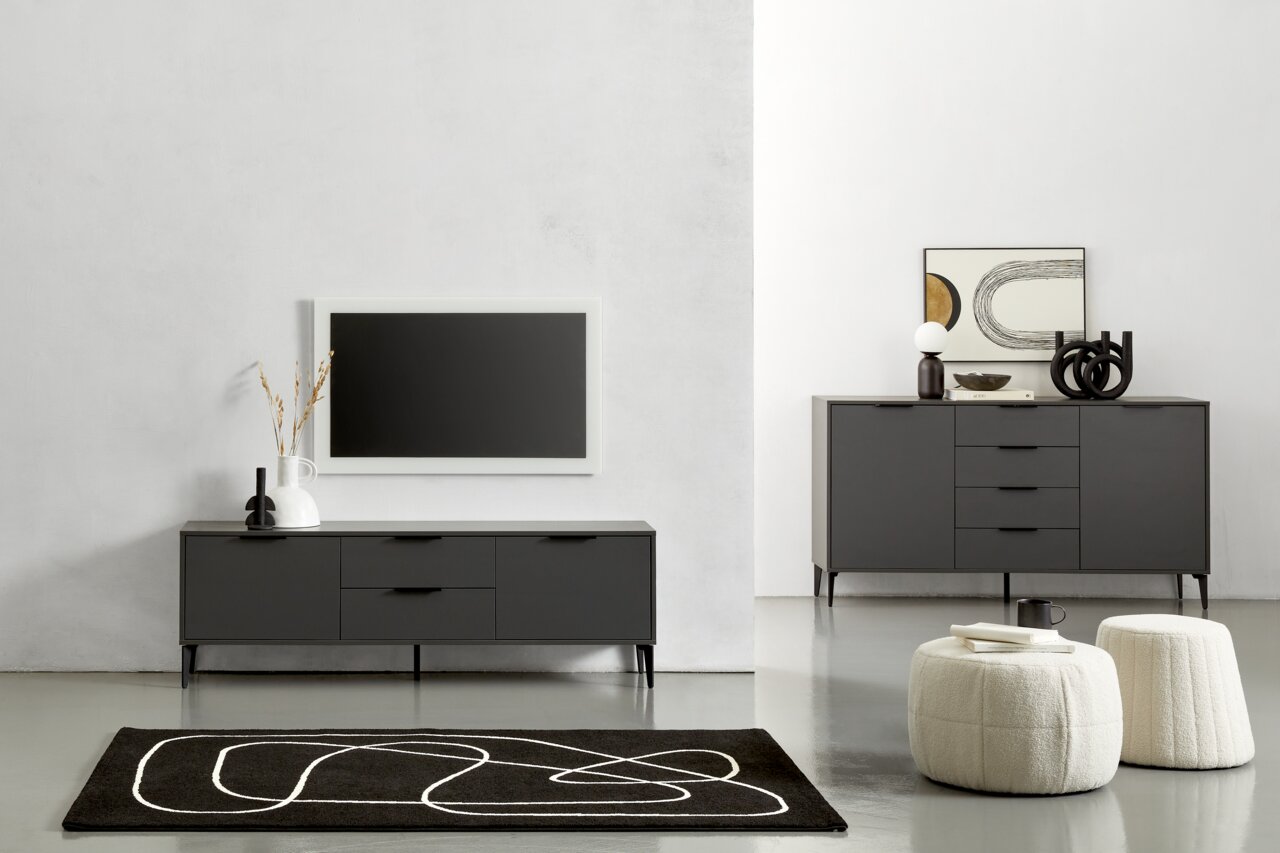 Moderne Wohnzimmermöbel in dunklem Grau, bestehend aus einem TV-Lowboard und einem Sideboard, mit dekorativen Elementen und einem Teppich im Vordergrund. Frontalansicht.