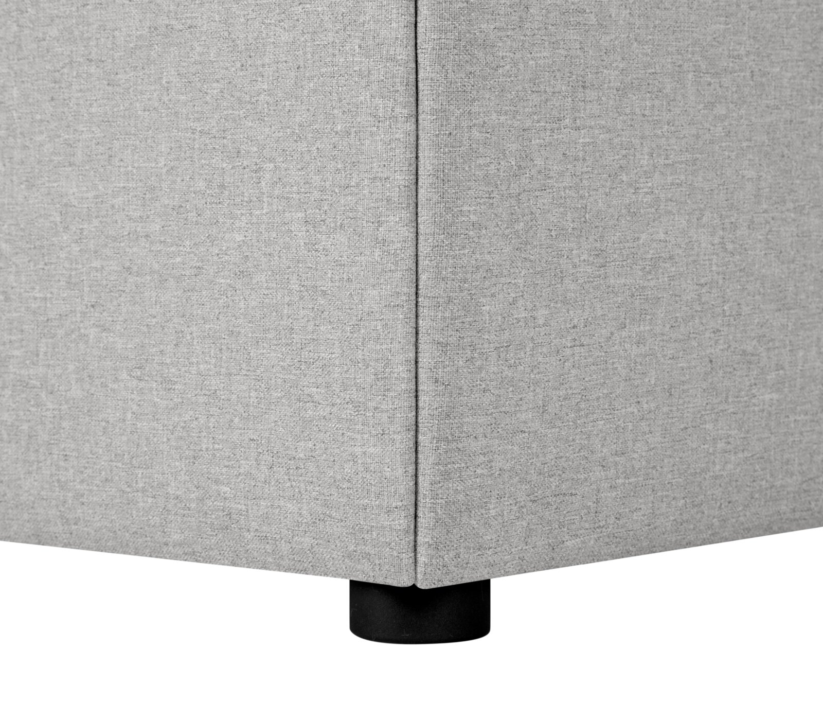 Nahaufnahme einer Ecke eines grauen Boxspringbetts mit schwarzem Fuß, seitliche Perspektive