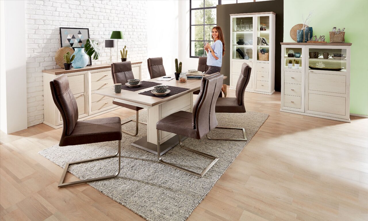 Esszimmer mit modernem Freischwinger-Stuhl und Funktions-Esstisch in heller Holzoptik, seitliche Perspektive