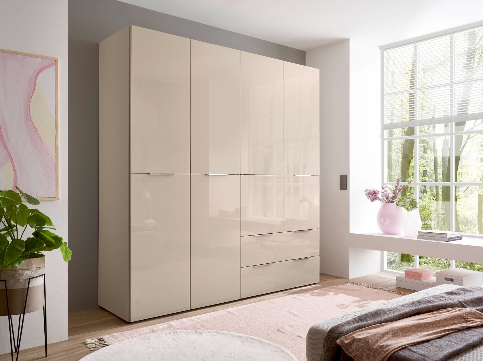 BOXXX Drehtürenschrank SANTORINI Beiger Kleiderschrank mit hochglänzenden Fronten, vier Türen und drei Schubladen im hellen Schlafzimmer neben großem Fenster, Ansicht schräg von vorne links.