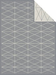 Grijze jacquarddeken met een geometrisch patroon van witte lijnen, bovenaanzicht