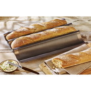 Een bakplaat met drie versgebakken baguettes, zijaanzicht