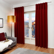 Roter Dekoschal J!Fina 130x250 cm, frontal vor einem Fenster in einem gemütlichen Wohnzimmer mit grauem Sofa und Stehlampe.