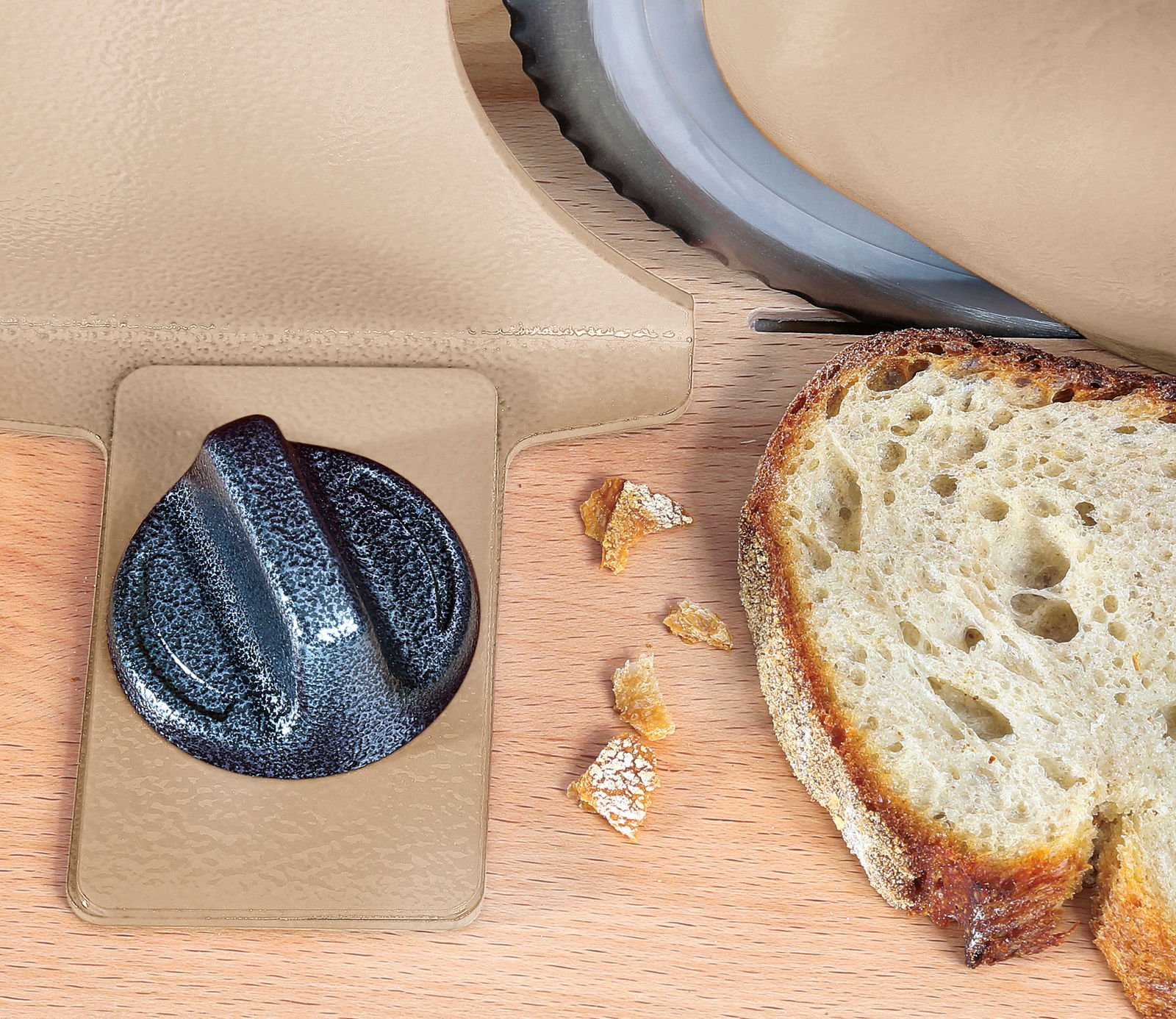 Brotschneidemaschine in Taupe mit Brotscheibe, Nahaufnahme von oben