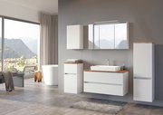 Moderne Badezimmeransicht mit einem weißen Unterschrank, Waschbecken und Spiegel, seitliche Perspektive.