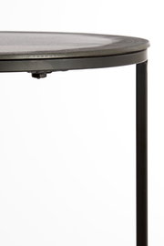 Nahaufnahme eines runden Beistelltisches mit schwarzer Metallkante und Bein, seitliche Perspektive