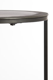 Nahaufnahme eines runden Beistelltisches mit schwarzer Metallkante und Bein, seitliche Perspektive