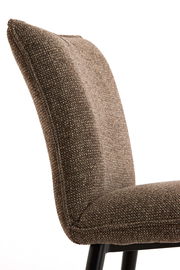 Nahaufnahme eines braunen, texturierten Stuhls mit schwarzem Metallgestell, seitliche Perspektive