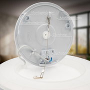 Rückansicht einer LED-Deckenleuchte mit Bewegungssensor, zeigt Montageplatte, Sicherheitsanker, Dichtung, Phasen- und Schutzleiteranschlüsse.