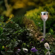 Solar Stabbeleuchtung in einem Garten, seitliche Perspektive, umgeben von grünen Pflanzen und Blumen.