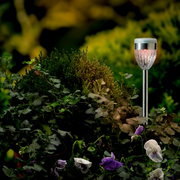 Zonne-energieverlichting in een tuin, zijaanzicht, omringd door groene planten en bloemen.