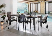 Modernes Outdoor-Esszimmer-Set mit rechteckigem grauem Gartentisch und sechs passenden Stühlen mit Netzbespannung auf einer überdachten Terrasse am Pool, Perspektive: leicht seitliche Frontansicht auf Tisch und Stühle