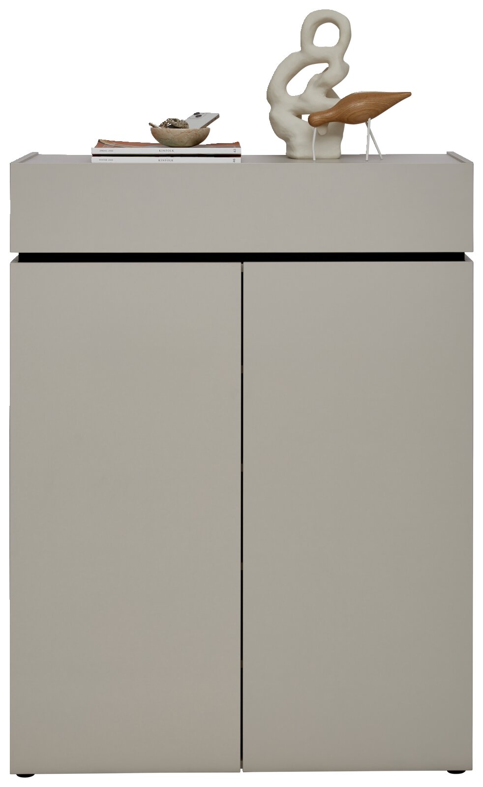 Moderner Schuhschrank in grauer Farbe mit zwei Türen, dekoriert mit einer Skulptur und Büchern auf der Oberseite, Frontalansicht.