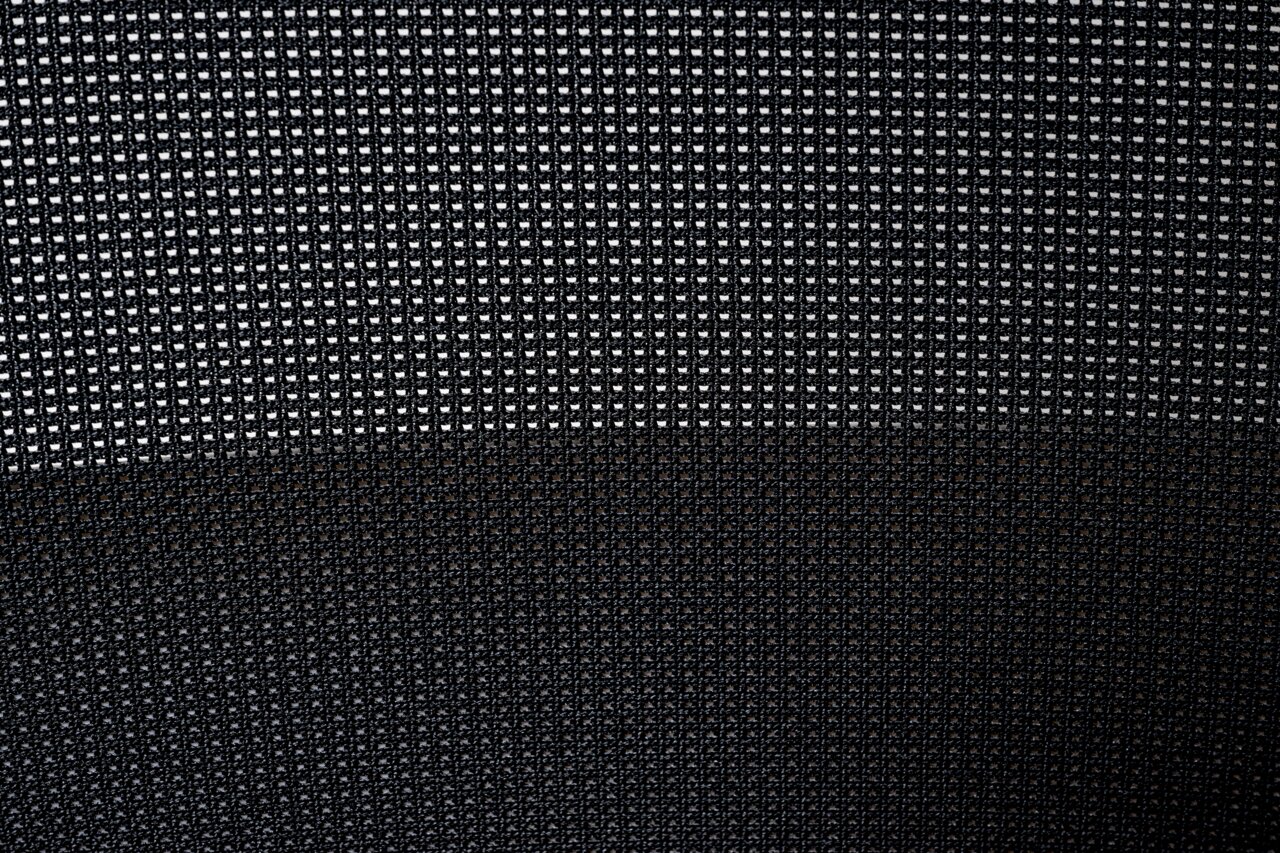 Nahaufnahme des Netzgewebes eines Drehstuhls, von vorne betrachtet.