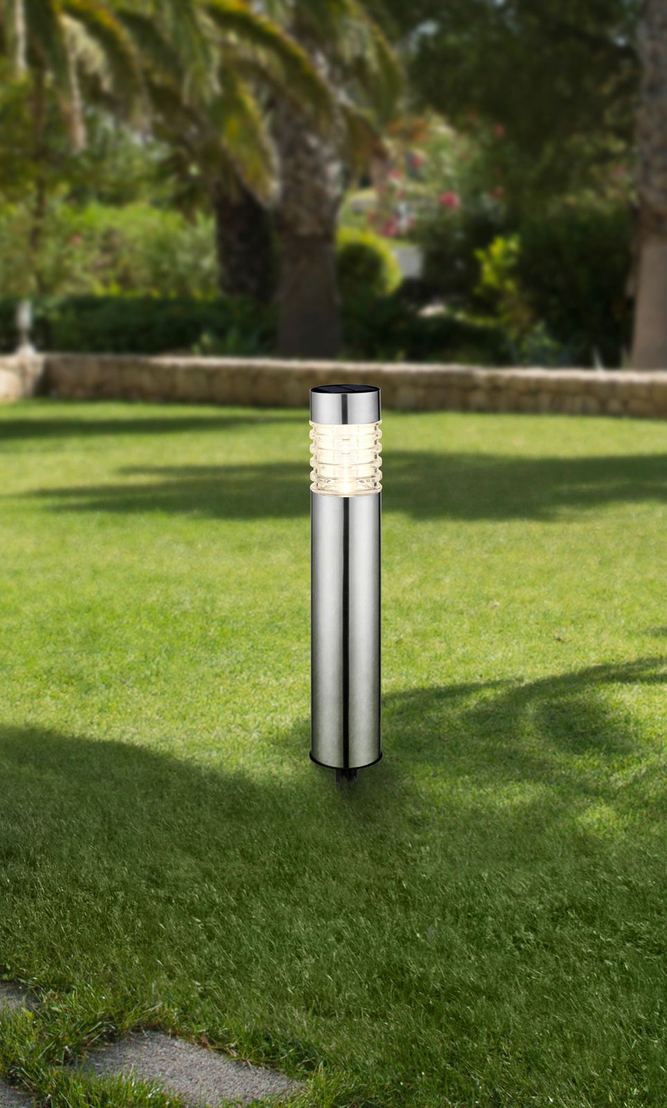 Solarleuchte im Garten, aus seitlicher Perspektive fotografiert, mit Edelstahlgehäuse und leuchtendem Kopf.