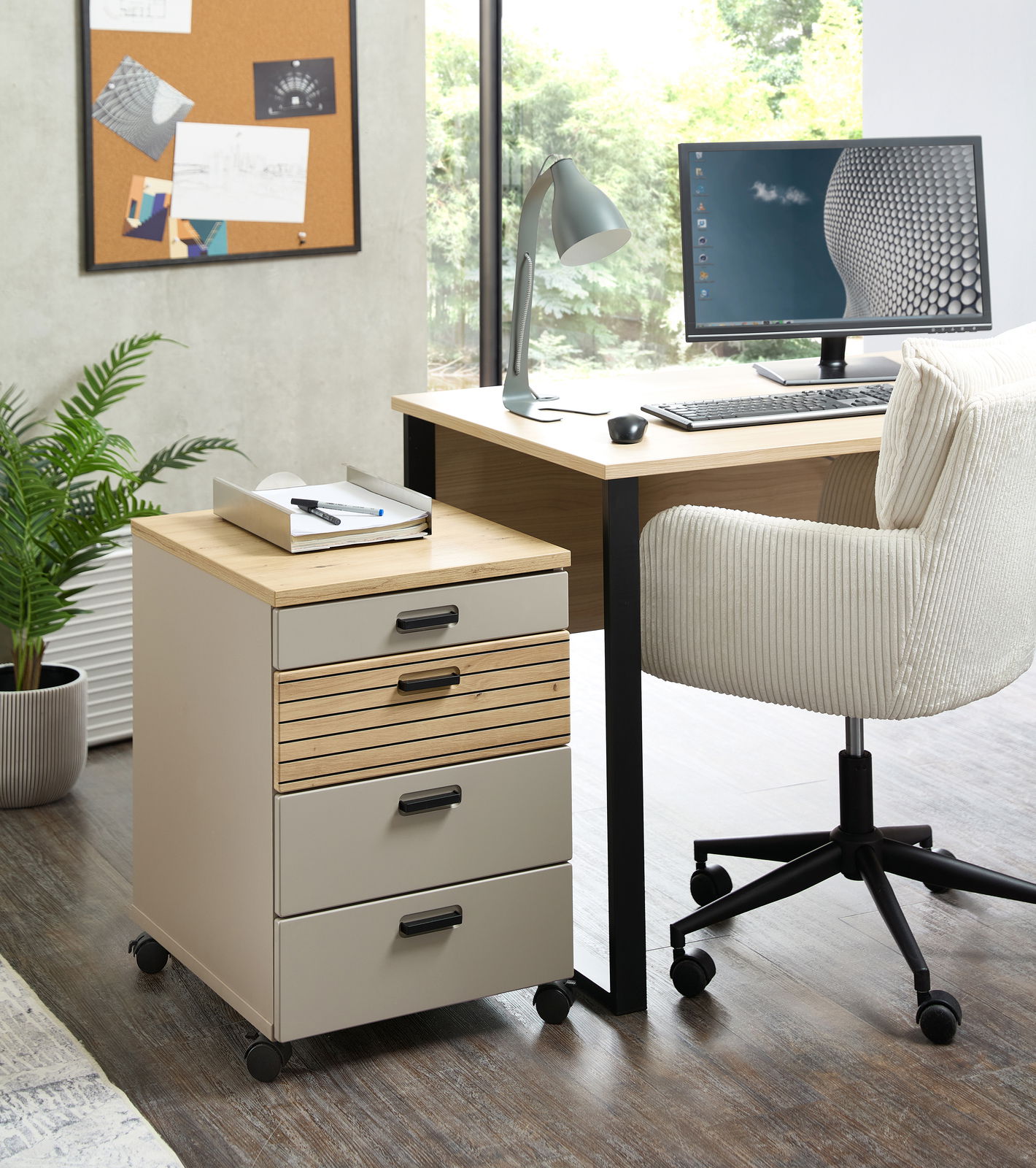 Rollcontainer mit vier Schubladen, auf Rollen, in einem modernen Büro neben einem Schreibtisch und einem Stuhl, aus der Perspektive von vorne links.