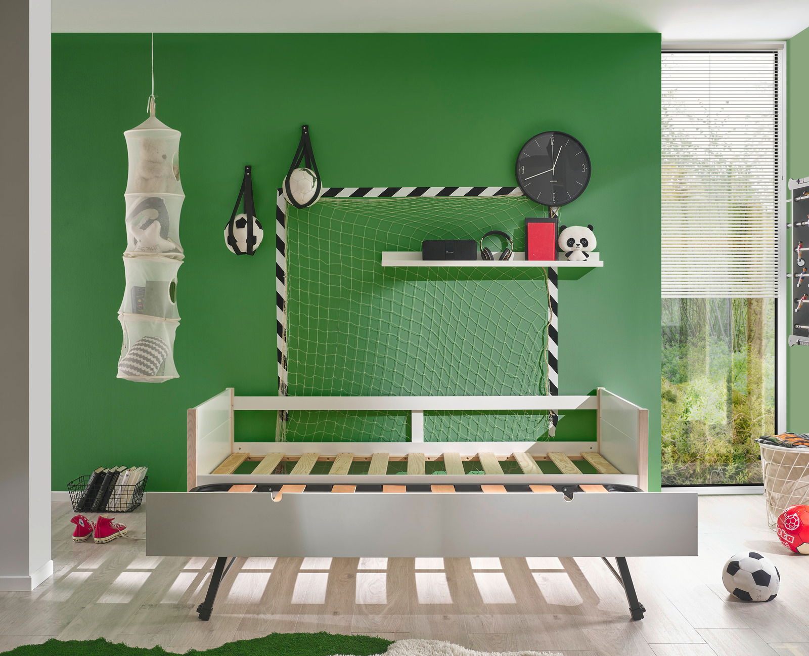 Jugendbett in einem Kinderzimmer mit grünem Fußballthema, seitliche Perspektive