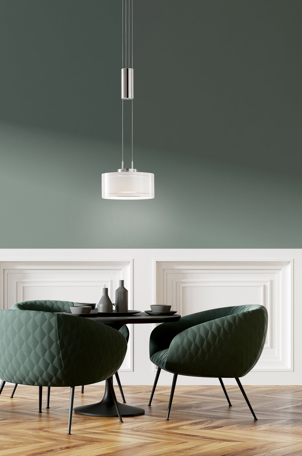 Moderne, runde Pendelleuchte mit weißem Glasschirm und Metallaufhängung über einem Esstisch mit zwei grünen Polsterstühlen in einem stilvollen Raum, Perspektive: leicht von unten in der Totalen.
