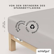 Spannbettlaken aus Bio-Baumwolle und Elasthan in Seitenansicht, geeignet für Matratzen bis zu 30-35 cm Höhe, mit Recycling-Verpackung.