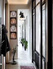 Fluransicht aus Augenhöhe mit vier quadratischen Tierporträt-Wandbildern (Tiger und Löwe) in vertikaler Anordnung, schwarzer Hängeleuchte und großem Fenster rechts