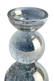 Decoratieve theelichthouder van helder rookblauw glas met luchtbeldetails en gestapelde bollen, vanuit licht verhoogd vooraanzicht.