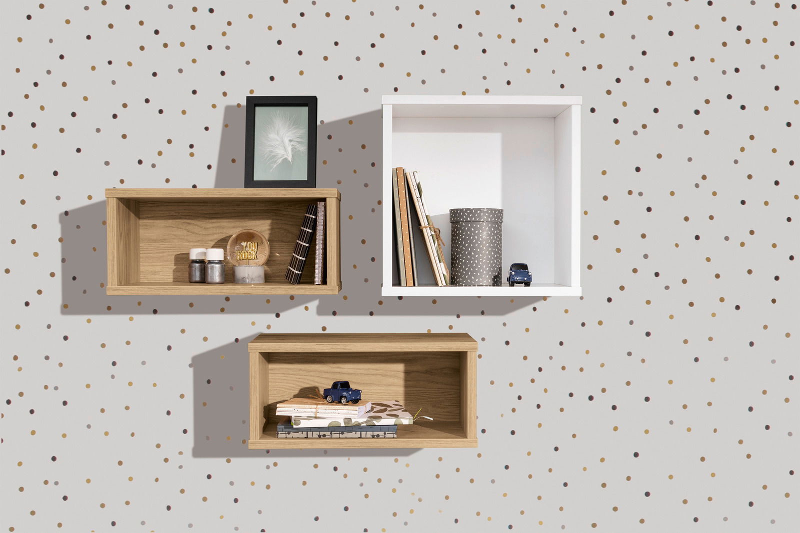 Drei Wandboxen in rechteckiger Form, zwei in Holzoptik und eine in Weiß, an einer gepunkteten Wand montiert. Perspektive von vorne.