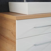 Nahaufnahme einer modernen Badkombination mit weißem Waschbecken und Holzoptik, seitliche Perspektive