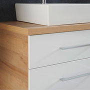 Nahaufnahme einer modernen Badkombination mit weißem Waschbecken und Holzoptik, seitliche Perspektive