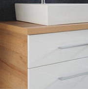 Nahaufnahme einer modernen Badkombination mit weißem Waschbecken und Holzoptik, seitliche Perspektive