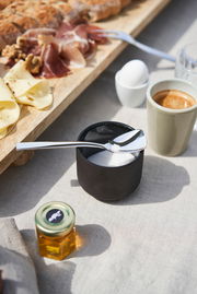 Eleganter Löffel aus dem Besteckset King 68-tlg., auf einem Tisch mit Frühstückszutaten, aus der Vogelperspektive fotografiert.