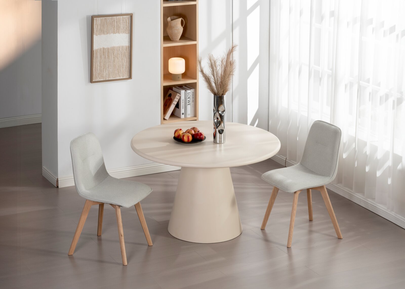 Zwei moderne, hellgraue Stühle mit Holzbeinen stehen um einen runden, beigen Tisch in einem hellen Raum mit großen Fenstern. Perspektive: seitlich.