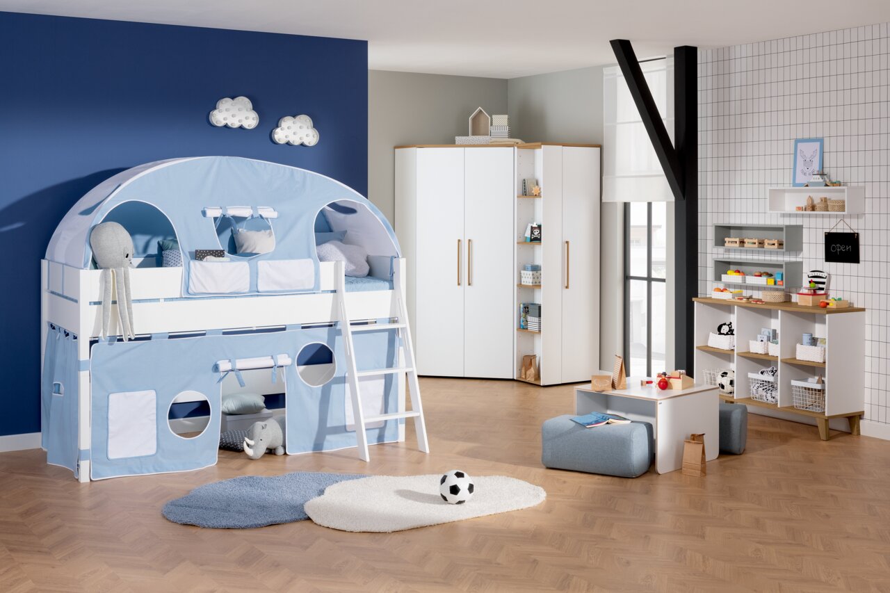 Spielbett Paidi TIAGO in einem Kinderzimmer mit blauer Zeltabdeckung und Leiter, aus der Perspektive von vorne links.