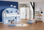 Spielbett Paidi TIAGO in einem Kinderzimmer mit blauer Zeltabdeckung und Leiter, aus der Perspektive von vorne links.