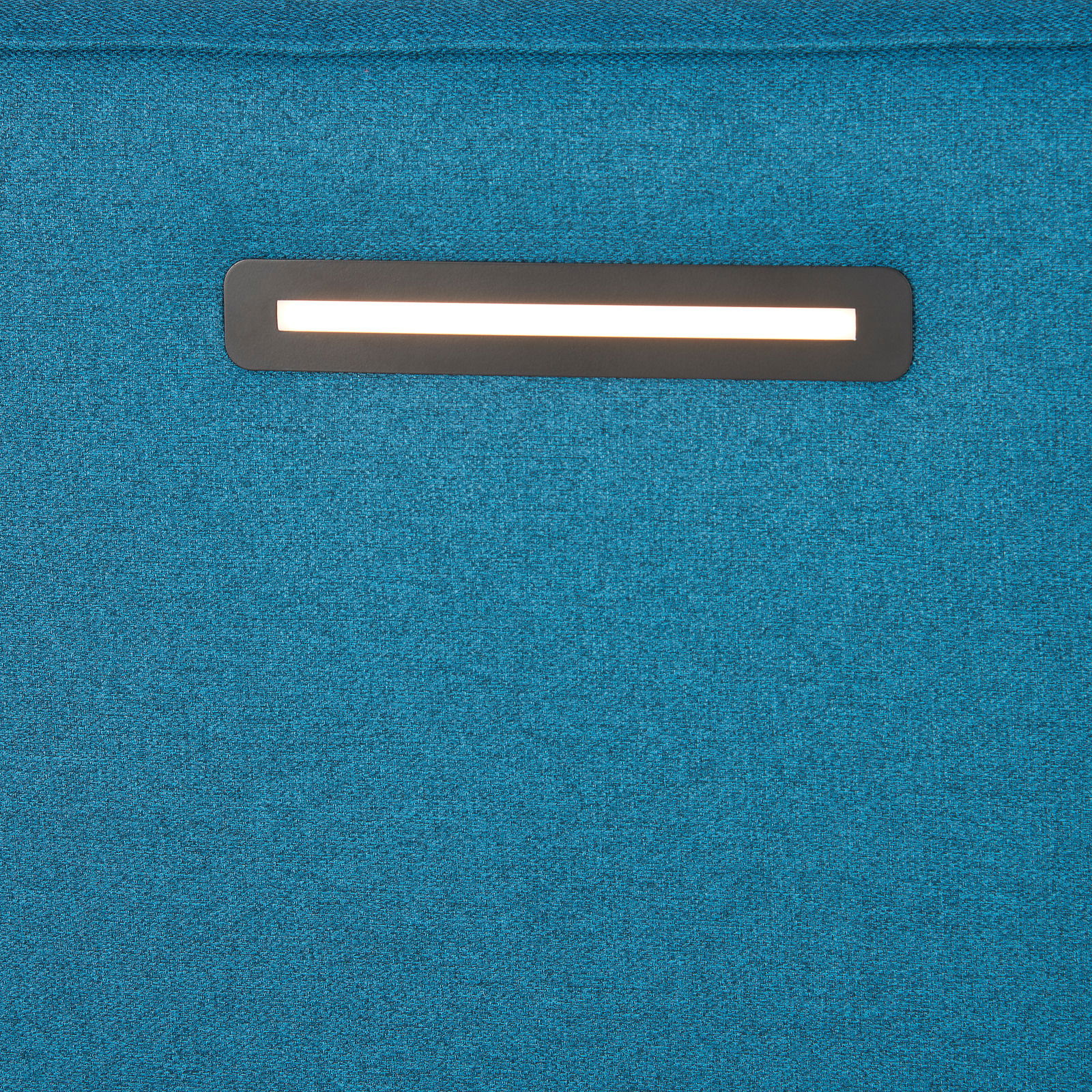 Nahaufnahme eines blauen Boxspringbetts mit integrierter Beleuchtung im Kopfteil.