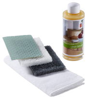 Pflegeset mit Renuwell Möbelöl, bestehend aus einer Flasche Öl und mehreren Reinigungstüchern, aus der Seitenperspektive fotografiert.