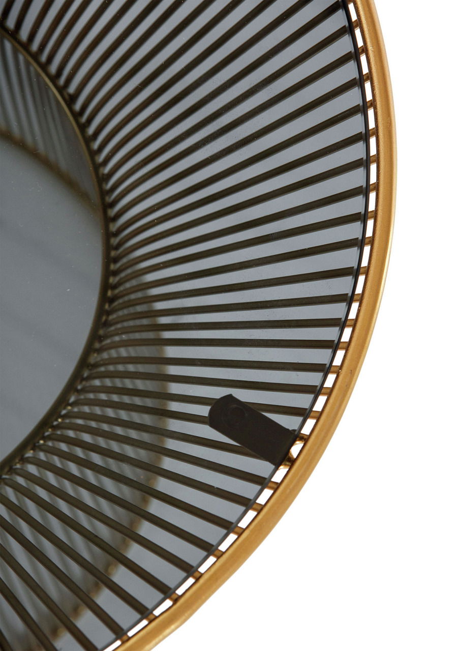 Nahaufnahme eines runden Beistelltisches mit einem goldenen Rahmen und einem Gitterdesign, von oben betrachtet.