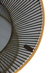 Nahaufnahme eines runden Beistelltisches mit einem goldenen Rahmen und einem Gitterdesign, von oben betrachtet.