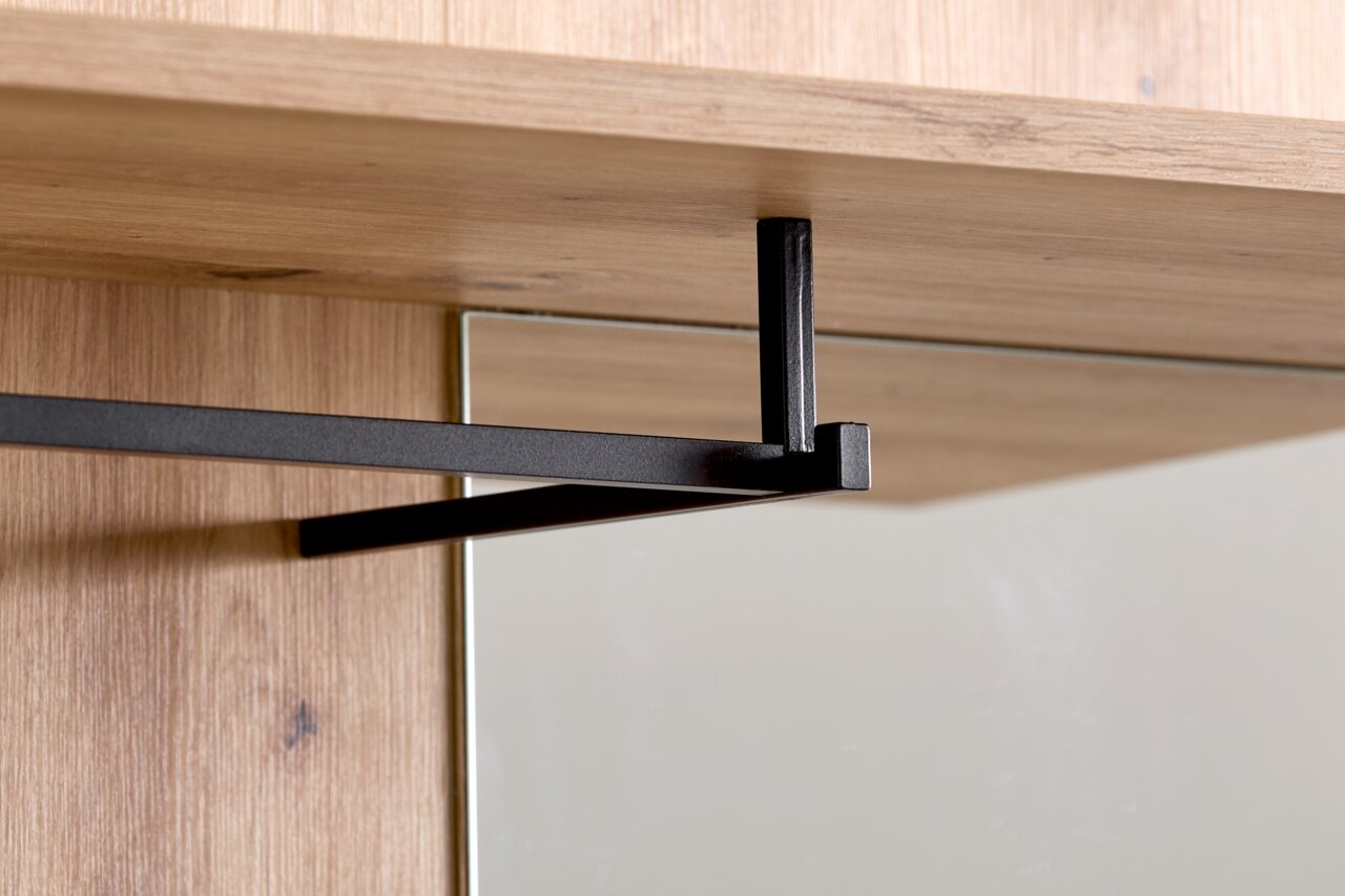 Nahaufnahme einer Kompaktgarderobe mit Holzoberfläche und schwarzer Metallstange, seitliche Perspektive.