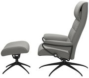 Grauer Einzelsessel mit passendem Hocker, seitliche Perspektive