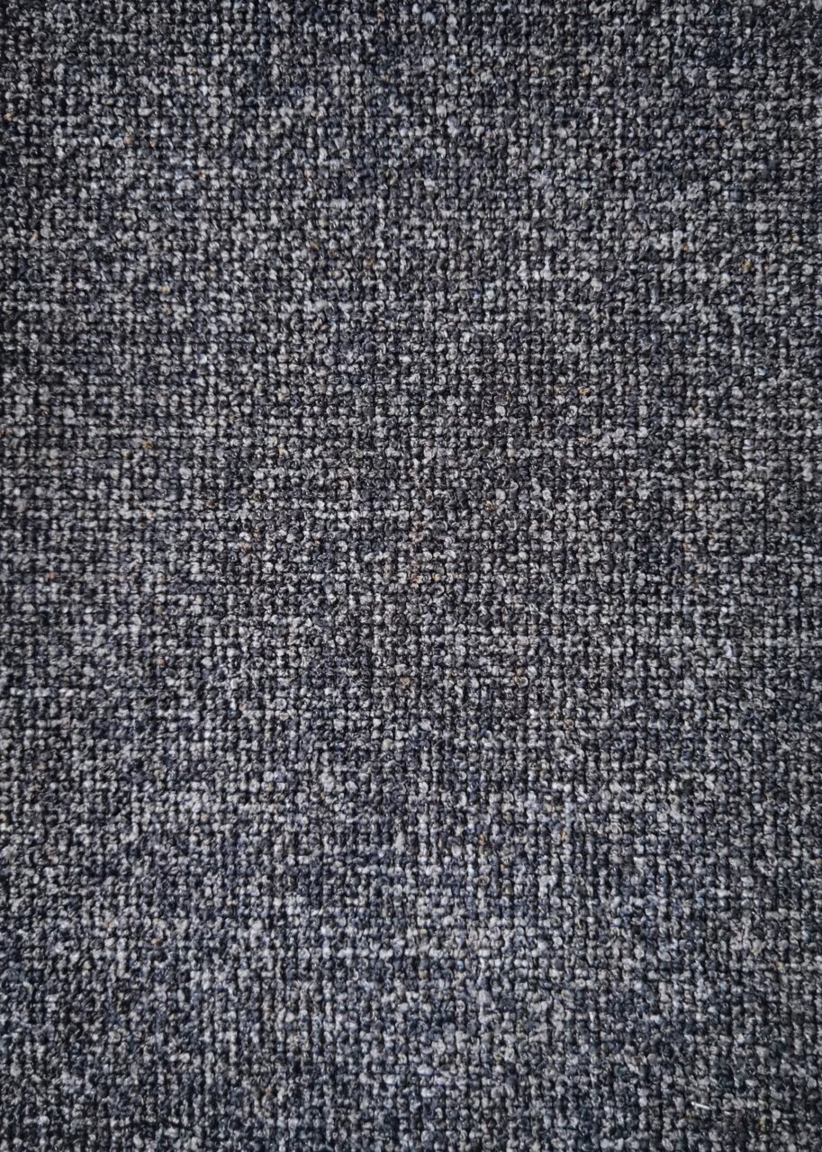 Nahaufnahme eines grauen, strukturierten Stoffes, von oben betrachtet