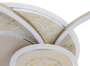 Close-up van een moderne led-plafondlamp met een cirkelvormig ontwerp en gouden accenten, gezien vanaf de zijkant.