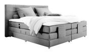 Graues Boxspringbett mit Kopfteil, seitlicher Perspektive, mit Kissen und Decke.