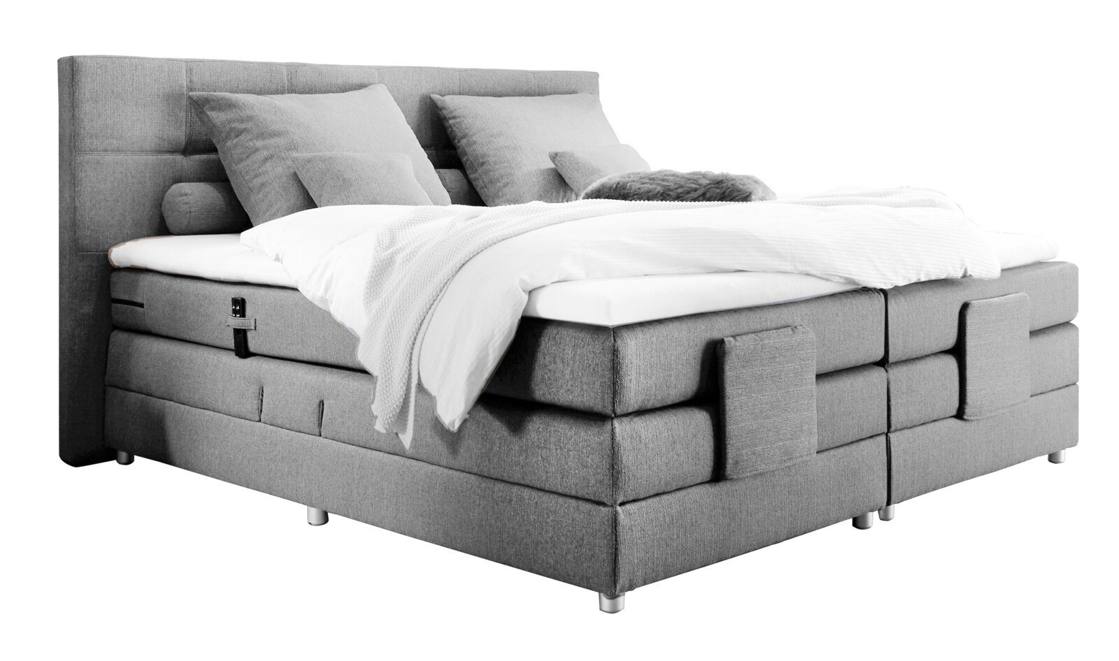 Graues Boxspringbett mit Kopfteil, seitlicher Perspektive, mit Kissen und Decke.