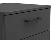 Nahaufnahme einer modernen, dunkelgrauen Kommode mit schlichter Griffleiste, perspektivisch von oben links fotografiert.